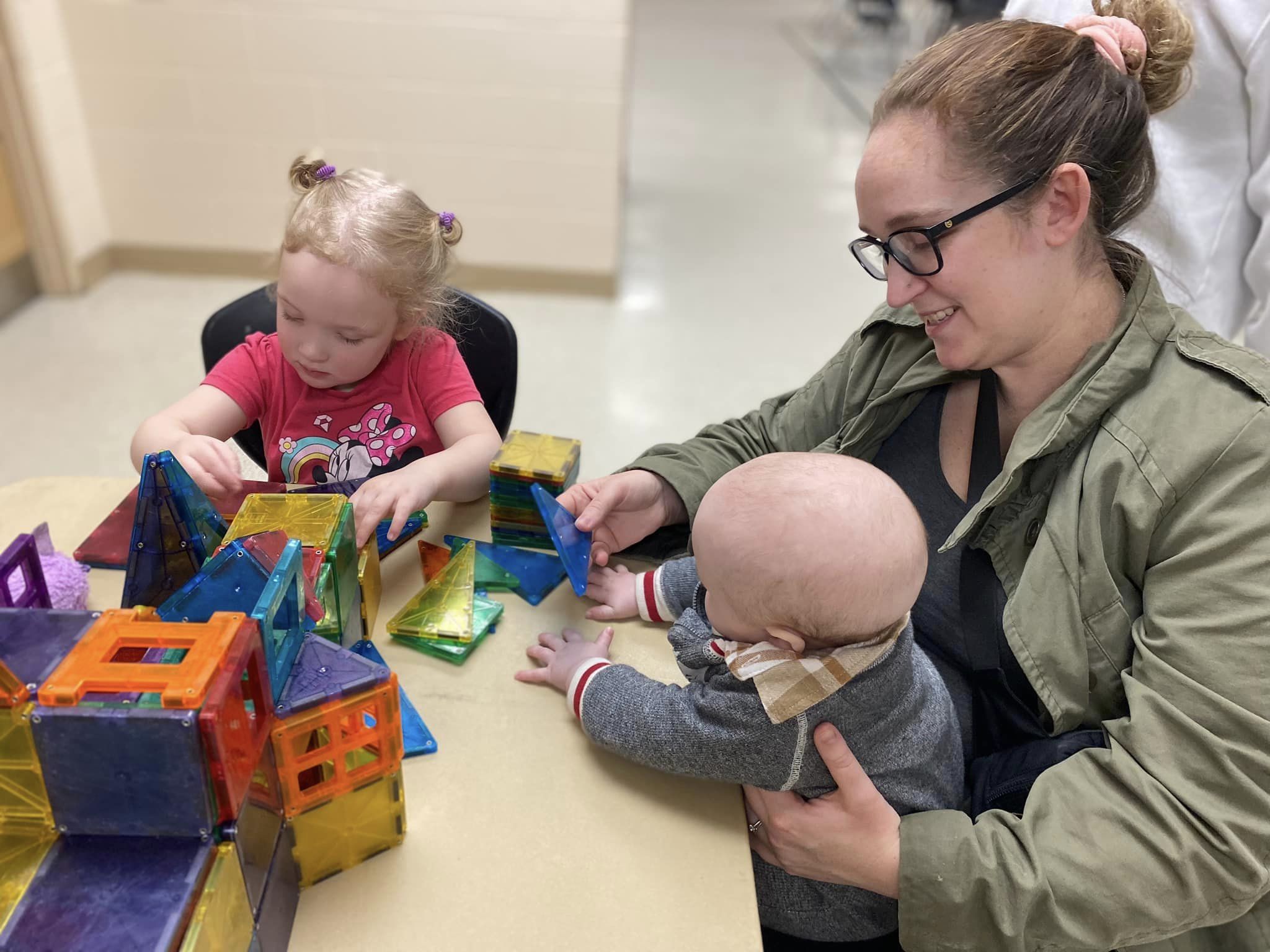 mom and two children playing with magnetic shapes