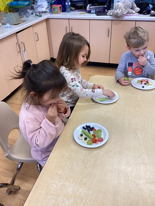 children at a table eating fruit