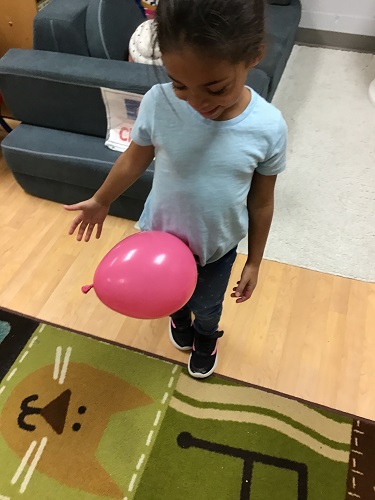 A balloon sticking to a child shirt due to static electricity