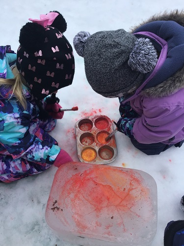 2 Preschool children painting ice with water paint
