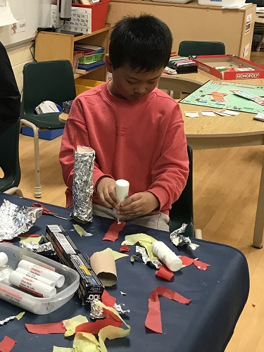 Child making Olympics torch with tin foil
