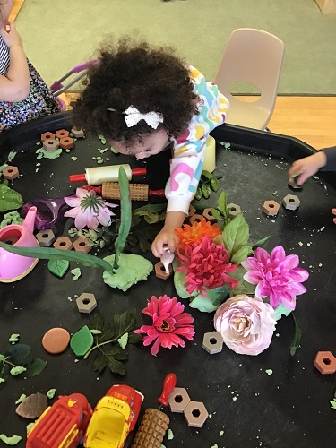 Toddler making flower out of playdough
