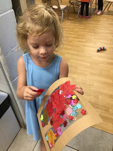 A child holding her artwork