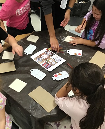 A group of children creating artwork at a table