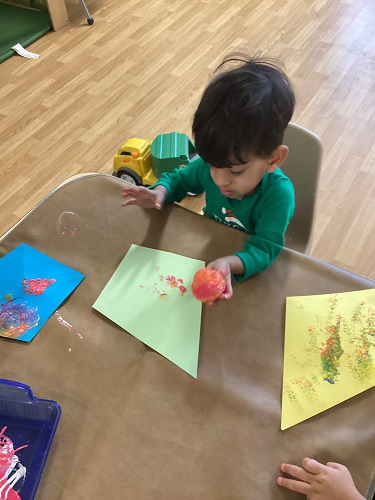 Children decorating construction paper kites at a table