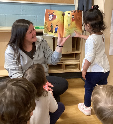 An educator reading a story to a group of children