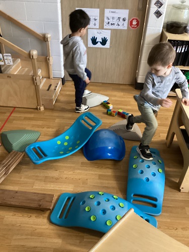 Two children walking along a balance beam course they created