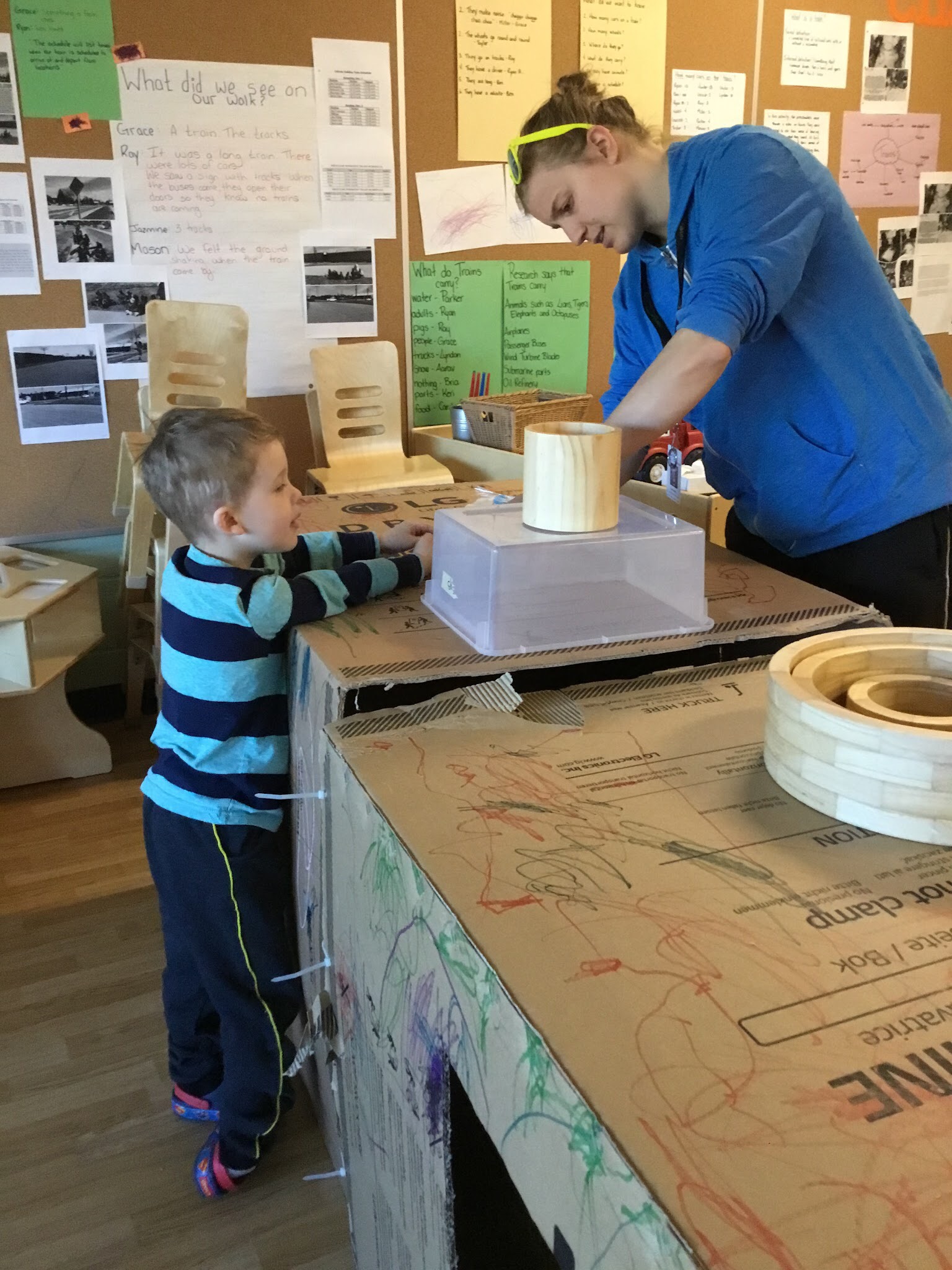 child and educator working on their train