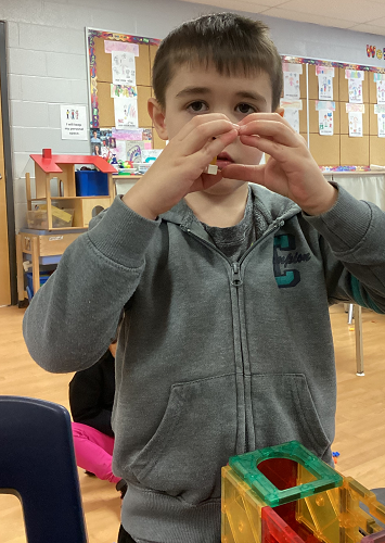 A child holding his fingers into a heart shape