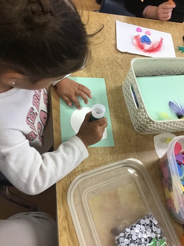 A child applying glue to paper