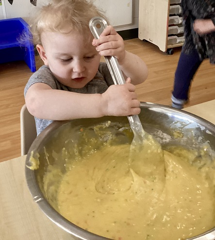A preschool child mixing the cake batter