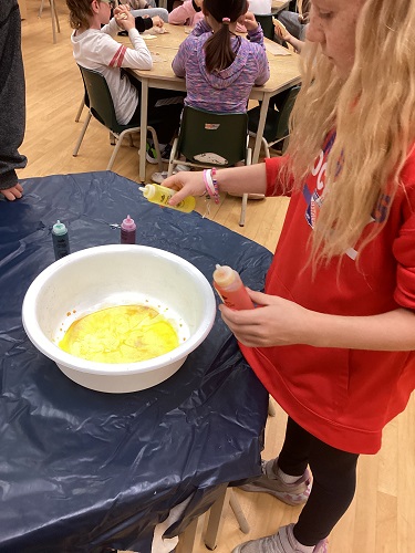 School-age girl dying coffee filter 