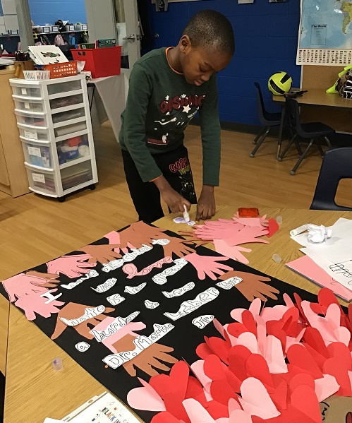 A school age child working on a poster highlighting Black History Month