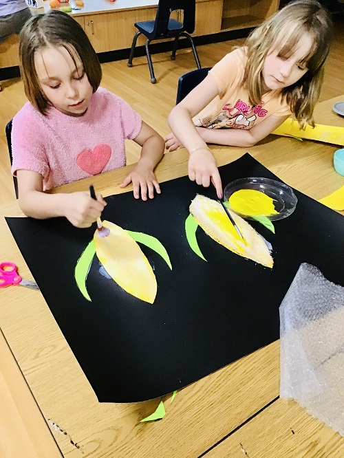 2 school age children working together on an art project