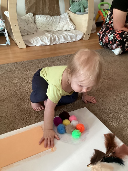 An infant child exploring a sensory board