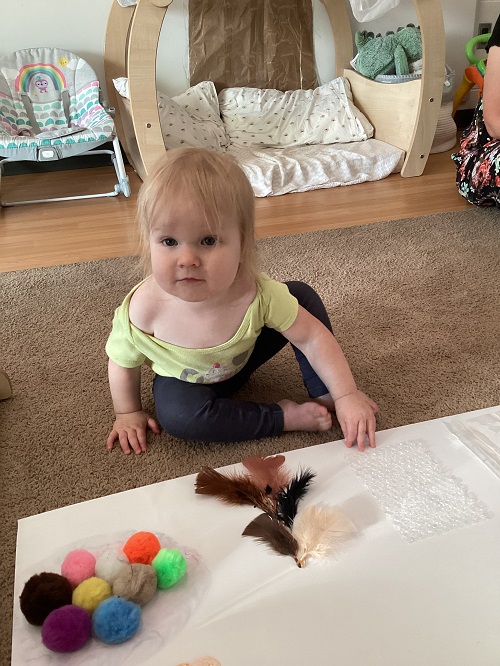 An infant child exploring a sensory board