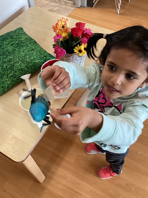 A child holding up a large bug figurine.