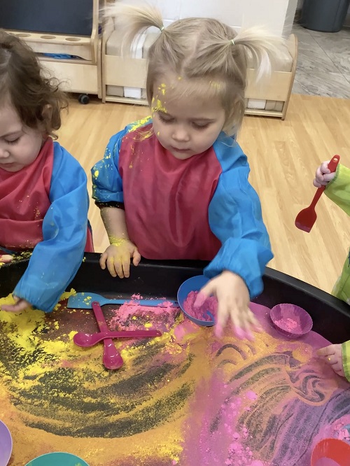 Toddler children playing with colourful powder for Holi