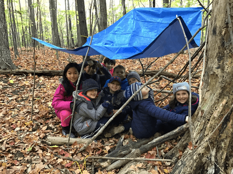 children gathering under a tarp