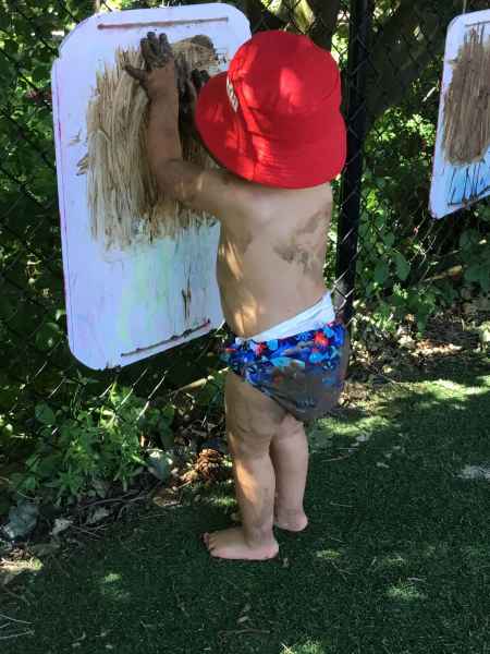 infant painting with mud