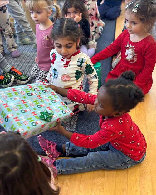 children sitting opening wrapped chirstmas gifts