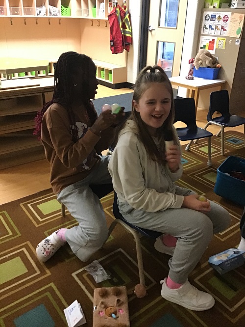 two children sitting on chairs, one in front of the other