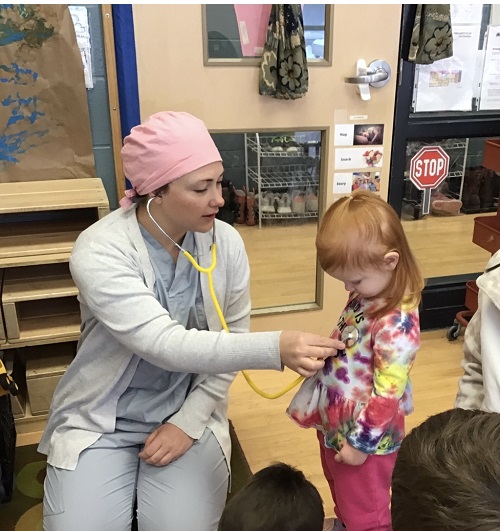 parent dressed as a nurse using stethoscope on another child
