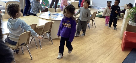 children sitting and walking around the classroom