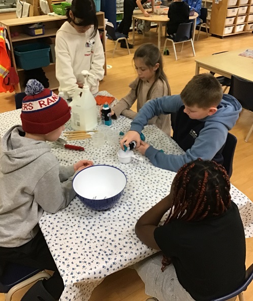 group of 5 children doing a sensory experiement to make dough