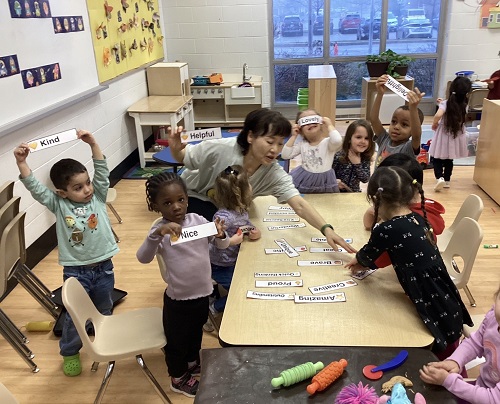 group of children and one educator showing their kind word labels