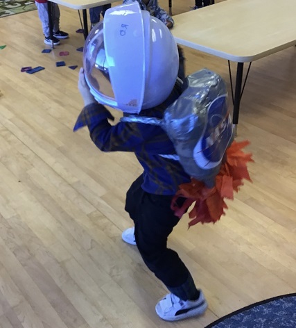 child pretending to be an astronaut with a helmet and space pack on
