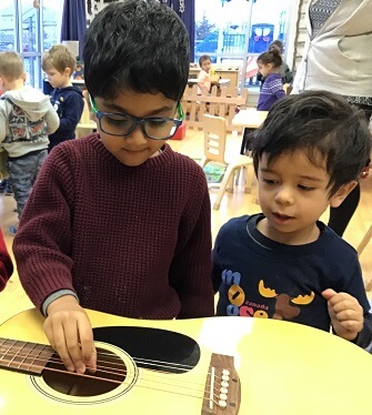 boys observing a guitar