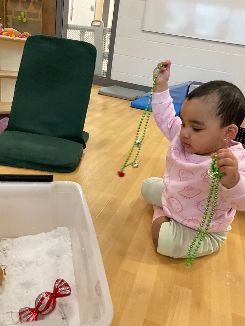 This month, the infants at RisingOaks Early Learning | St. Patrick welcomed the holiday season by playing with different elements that represent it, such as the snow, the ornaments, and jingle bells! They engaged in unique ways exploring their senses, interests and experimenting cause and effect.