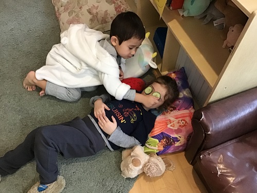 child laying down with cucumbers on their eyes