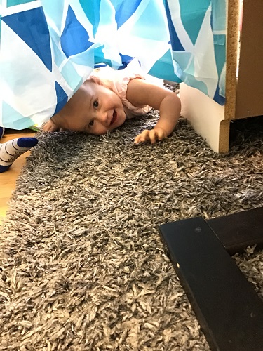 child peeking out from behind a sheet