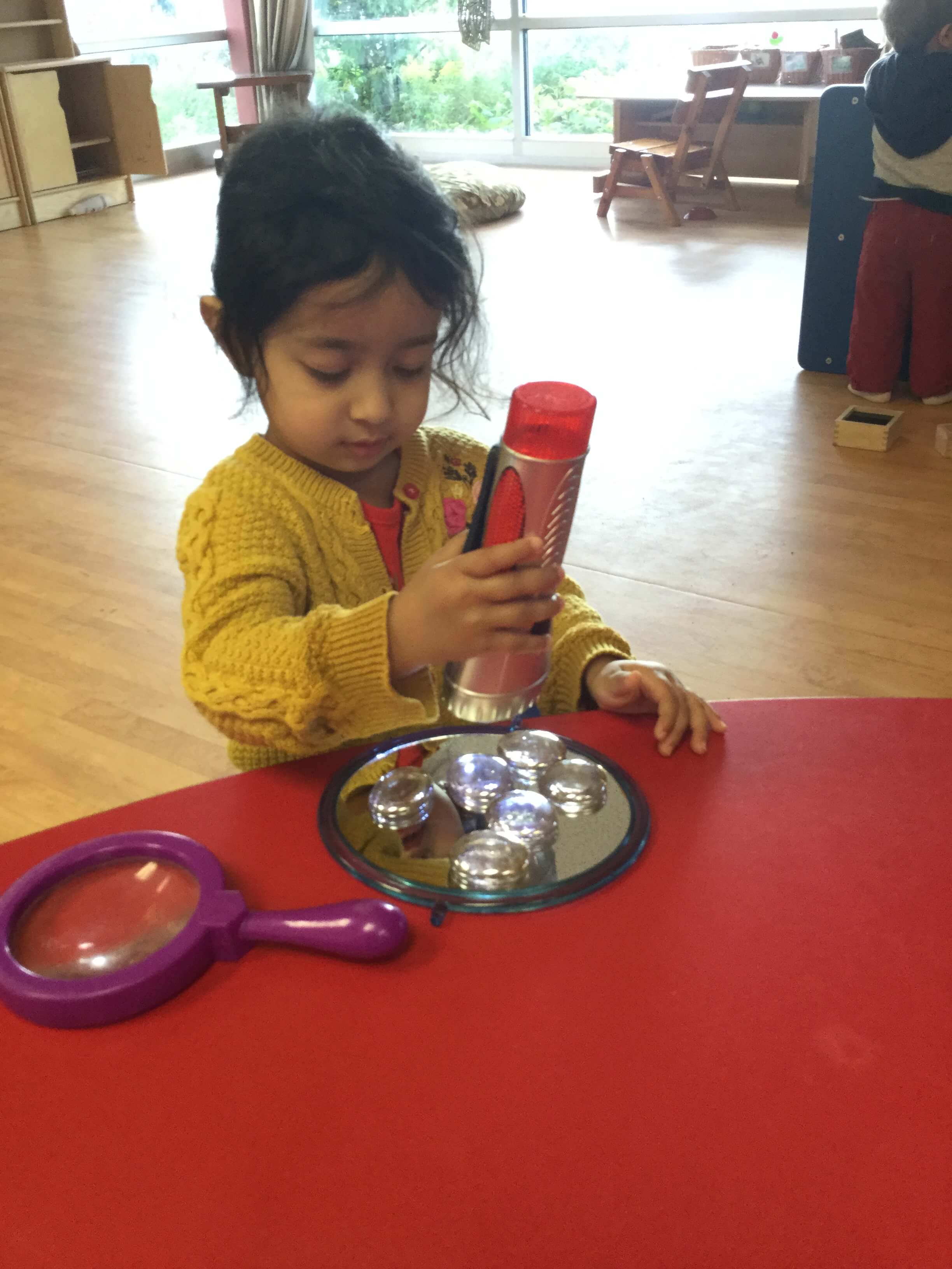 girl using flashlight observing reflection