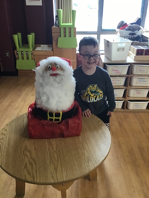 child posing with a homemade santa