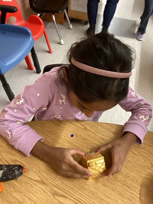 child adding gems to their gingerbread house