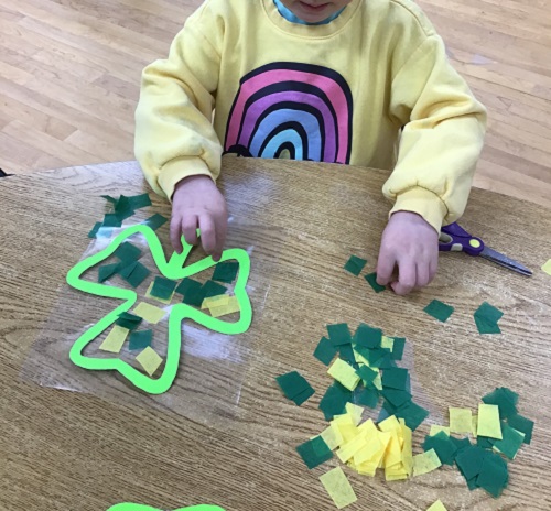 child putting paper onto their shamrock