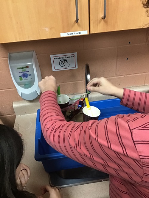 educator placing a boat into the water