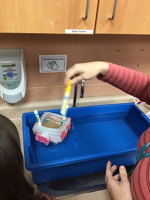 educator placing markers into a boat