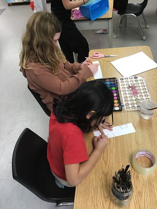 a group of children working on their bookmarks on a table