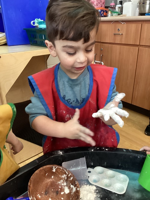 child observing baking soda on his hand