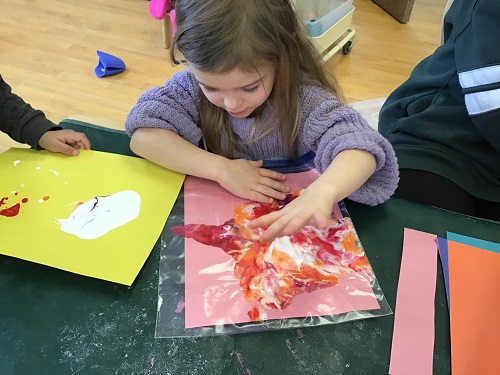 Child squishing paint in a Ziplock bag