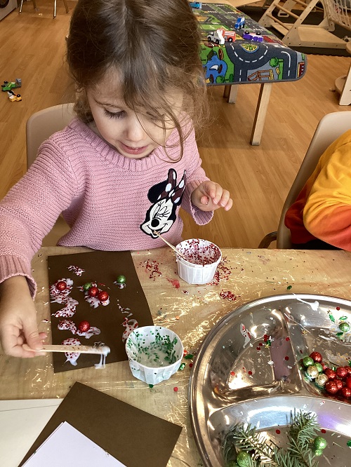 A child engaged in an art experience with open-ended materials.