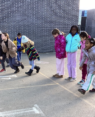 A group of children outside on the playground playing a game.