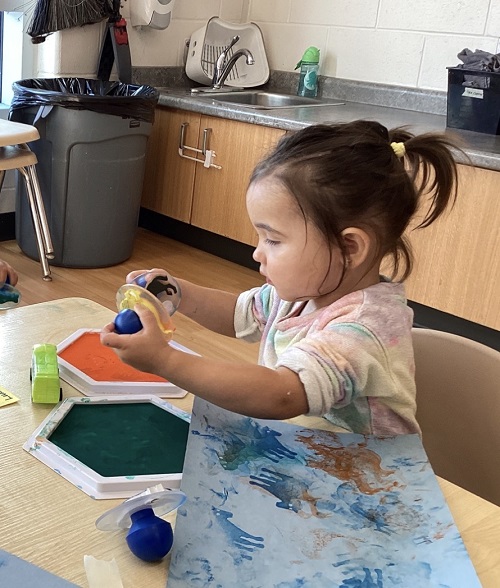 A toddler child using stamps