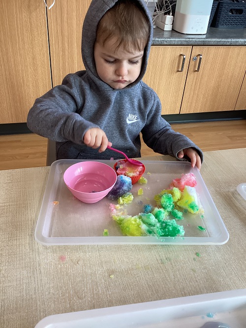A child exploring with colours and snow.