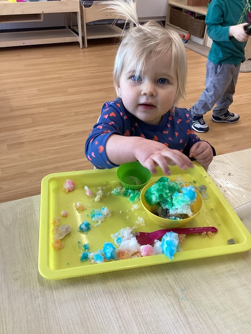 A child exploring with colours and snow.