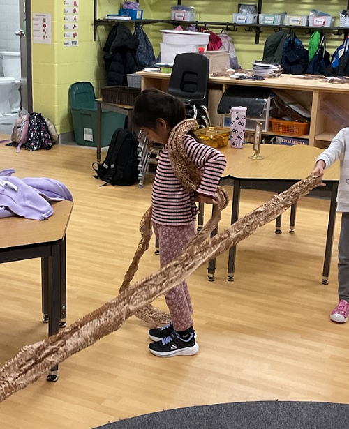 child wrapping material around her body